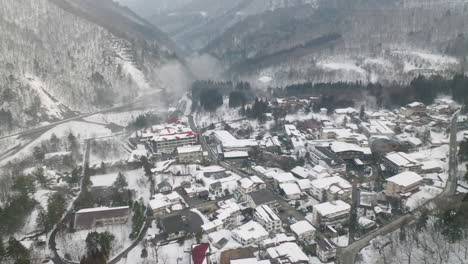 Dächer-Von-Dorfhäusern-Bedeckt-Im-Winterschnee-Mit-Nebel-In-Okuhida-Hirayu-Onsen,-Gifu,-Japan