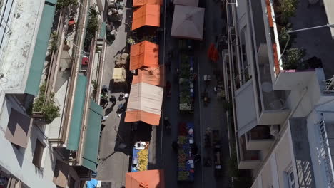 Aerial-drone-shot-pulling-away-from-busy-street-market-Athens-Greece