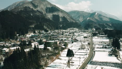 Drone-shot-of-Japanese-countryside-in-winter,-Okuhida-village-covered-in-snow