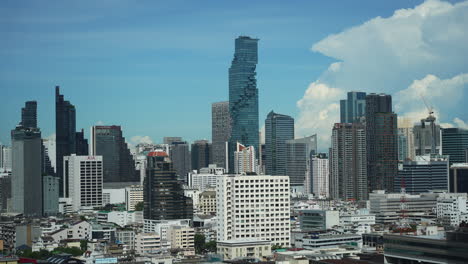 King-Power-Mahanakhon,-formerly-known-as-MahaNakhon,-is-a-mixed-use-skyscraper-in-the-Silom-Sathon-central-business-district-of-Bangkok,-Thailand,-Timelapse-of-Clouds-and-Cars-daytime