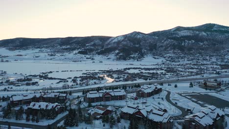 Statischer-Blick-Von-Oben-Auf-Die-Schneebedeckten-Dampfschiffquellen-In-Colorado-Mit-Skihütten-Und-Resort-Bei-Einem-Wintersonnenuntergang
