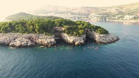 Aerial-view-of-a-group-of-tourists-on-a-kayak-tour-passing-by-Lokrum-Island-near-Dubrovnik-on-the-Adriatic-coastline-of-Croatia