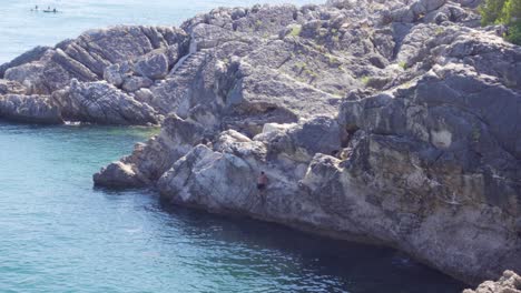 A-Person-Climbing-the-Cliff-from-the-Water