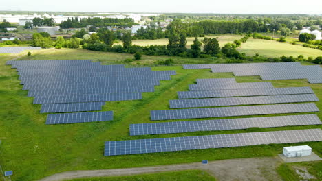 Ground-mounted-solar-panels-in-rows-at-power-station-covered-by-shade-of-cloud