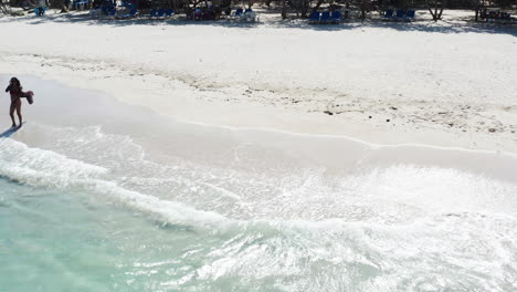 Touristenfrau-Setzt-Am-Tropischen-Strand-Eine-Sonnenbrille-Auf---Drohnenrutsche-Rechts