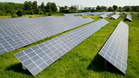 Slow-low-angle-flight-over-Photovoltaic-power-station-or-solar-park-installed-on-meadow-in-wilderness