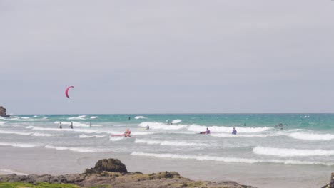 Muchos-Surfistas-Y-Windsurfistas-En-El-Mar-Ventoso-Junto-A-La-Praia-Do-Guincho,-Portugal