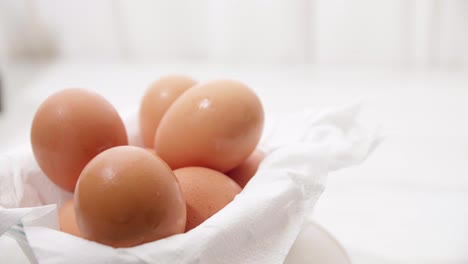 Close-up-male-hand-putting-brown-eggs-to-the-carton