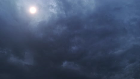 4k-Zeitraffer-Der-Sonne,-Die-Hinter-Dunklen-Wolken-Am-Himmel-Scheint