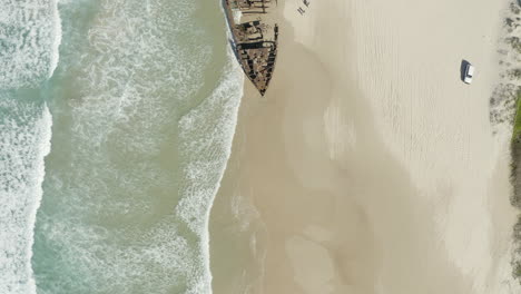 Wide-top-view-drone-shot-of-the-old-shipwreck,-SS-Maheno,-on-a-beach-of-Fraser-Island,-Australia
