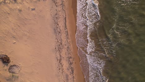 Birds-eye-view-going-up-from-waves-breaking-in-the-sandy-shore-in-a-Caribbean-Sea-beach