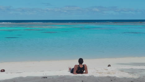 Woman-admires-ocean-while-relaxing-on-Maré-Island-beach