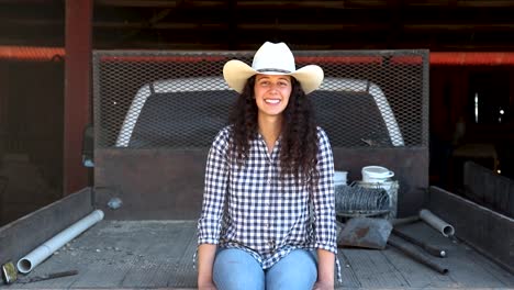 Cowgirl-smiles-at-camera-in-dusty-flatbed-truck