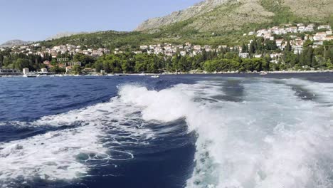 Sunny-summer-day-on-the-Adriatic-Sea,-with-powerboat-living-white-foam-behind-near-Dubrovnik,-Croatia