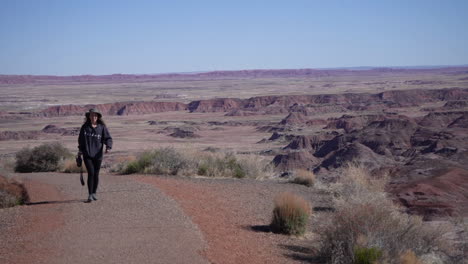 Female-Landscape-Photographer-on-Desert-HIking-Trail,-Petrified-Forest-National-Park,-Arizona-USA,-Full-Frame-Slow-Motion
