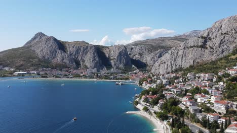 Massive-steel-grey-mountains-above-Omis,-a-coastal-town-in-Croatia,-an-aerial-view