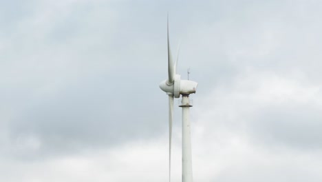Wind-turbine-blade-rotating-in-a-cloudy-weather,-close-up-sky-background
