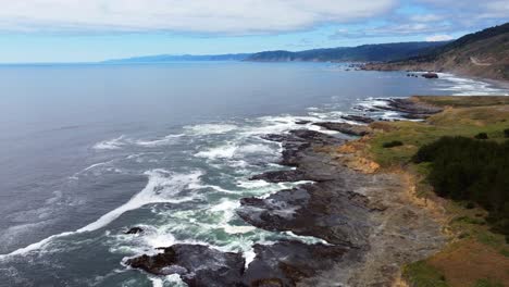 4k-30fps-Luftaufnahmen-Oregon-Coast---Fliegende-Drohnenaufnahme-Der-Kalifornischen-Oregon-Grenzküste---Weißbedeckte-Pazifische-Meereswellen,-Die-Gegen-Die-Felsige-Küste-Und-Die-US-Route-101-Im-Hintergrund-Krachen