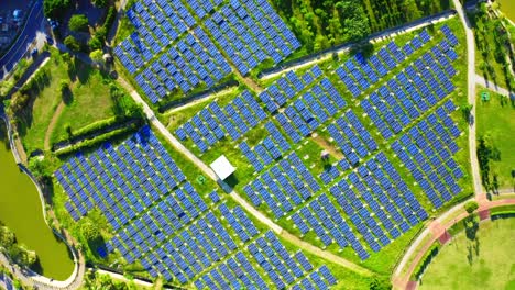 Aerial-birds-eye-shot-of-renewable-solar-panel-farm-on-grass-field-during-sunny-day-in-South-East-Asia
