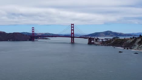 Drohnenaufnahmen-Aus-Der-Luft-Von-San-Franciscos-Weltberühmter-Golden-Gate-Bridge---Bewölkter-Himmel-Und-Ruhiges-Buchtwasser-Und-Wellen