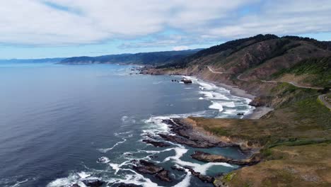 4K-30FPS-Aerial-Footage-Oregon-Coast---Static-drone-shot-of-US-Route-Highway-101---ocean-waves-crash-against-oceanside-rock-formations-as-people-road-trip-down-the-The-Royal-Road-into-North-California