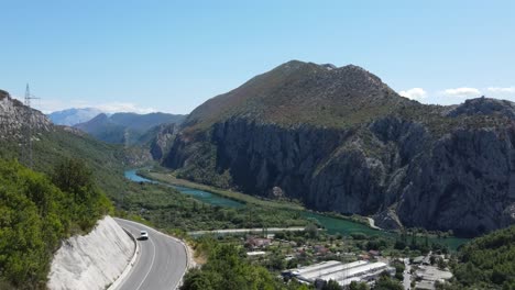 Winding-road-and-green-river-Cetina-in-Omis,-Croatia,-an-aerial-footage