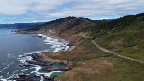 4k-30fps-Luftaufnahmen-Küste-Von-Oregon---Statische-Aufnahme-Von-Uns-Route-Highway-101---Meereswellen-Krachen-Gegen-Felsformationen-Am-Meer,-Während-Menschen-Die-Pnw-Küste-Hinunterfahren---Epische-Naturlandschaft