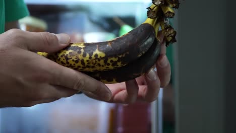 Manos-Masculinas-Sosteniendo-Trozos-De-Plátanos-Demasiado-Maduros-Con-Manchas-Oscuras