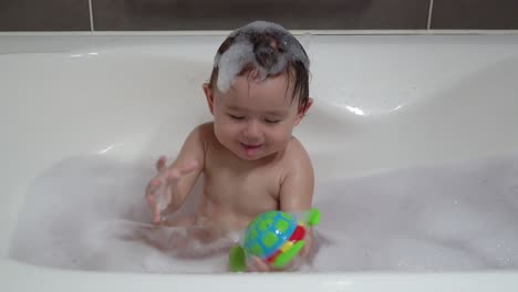 Fröhliches-Kleinkind,-Das-Glücklich-Mit-Plastikspielzeug-Spielt,-Während-Es-In-Der-Badewanne-Badet