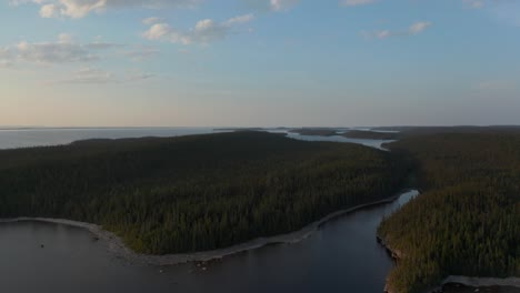 Drone-flying-over-a-beautiful-large-lake-and-forest-at-dusk