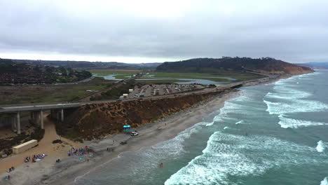 Foamy-Sea-Waves-Washing-Shore-At-Torrey-Pines-State-Beach,-San-Diego,-California---aerial-drone-shot