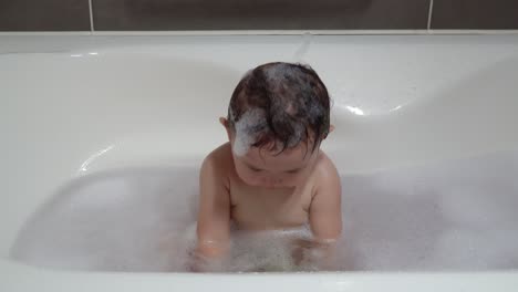 Babymädchen-Klatscht-In-Die-Hände-Weiß-Unter-Schäumendem-Bad