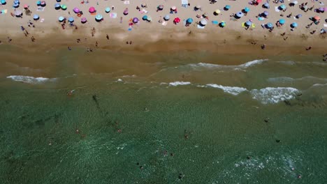 Bird's-eye-view-of-people-swimming-and-enjoying-in-the-sea-at-Calpe-Beach