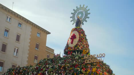 Statue-Der-Jungfrau-Maria-Auf-Einer-Mit-Blumen-Geschmückten-Plattform-Am-Plaza-Del-Pilar-Während-Der-Fiestas-Del-Pilar-In-Zaragoza,-Aragon,-Spanien