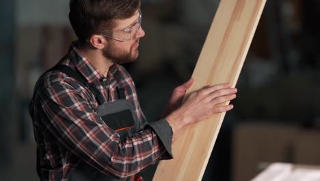 A-focused-bearded-carpenter-inspects-the-board