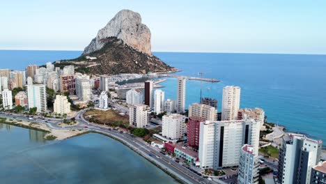 Panoramic-view-of-buildings-in-the-foreground-and-in-the-background-the-Penyal-d'Ifac-Natural-Park-in-Calp,-Alicante,-Spain