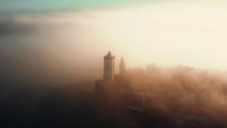 Verlassene-Mittelalterliche-Stadt-Und-Burgturm,-Die-Bei-Sonnenaufgang-Durch-Dichten-Nebel-Ragen
