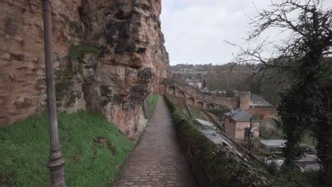 Walking-alone-in-the-Grund-district-between-the-Bock-Casemates-and-Alzette-river-in-Luxembourg-City
