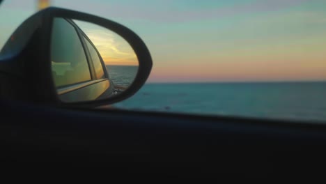 Rearview-mirror,-driving-at-sunset