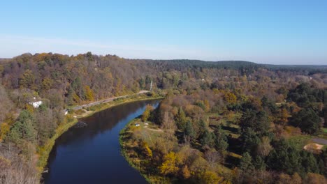 AERIAL-Orbiting-Shot-of-a-River-Bend-in-Rural-Outskirts-of-Vilnius,-Lithuania-during-Autumn
