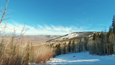 Wunderschöner-Verschneiter-Weg-In-Einem-Skigebiet-In-Colorado-An-Einem-Bewölkten-Wintertag,-Umgeben-Von-Hohen-Espen-Und-Pinien-Mit-Atemberaubenden-Orangen-Und-Roten-Wüstenfarben-Im-Hintergrund