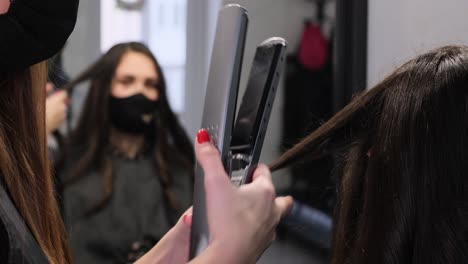 Professional-hairdresser-uses-a-curling-iron-while-doing-a-hairstyle