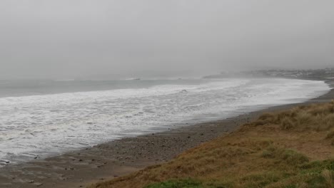 Nebel-An-Einem-Stürmischen-Tag-Bedeckt-Einen-Meeresstrand-Mit-Starken-Winden-Und-Wellen