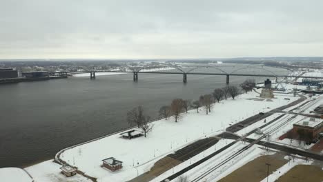 Drone-Flies-Toward-Centennial-Bridge-in-Winter,-from-Davenport,-Iowa