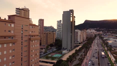 Drone-clip-flying-over-traffic-and-luxurious-hotels-during-sunset-in-the-city-of-Calpe-in-Spain