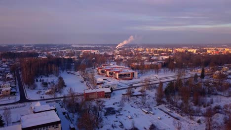 Rising-up-over-city-of-Valmiera-in-the-winter-sunrise---Extreme-wide-aerial-view