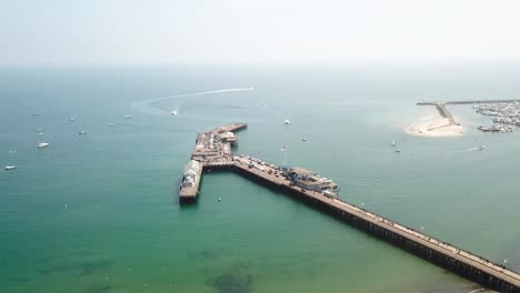 Aerial-dolly-towards-Santa-Barbara-pier-with-blue-skies-and-water-as-well-as-boats-in-the-water