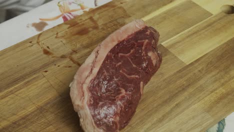 Chef-takes-out-meat-steak-from-plastic-vacuum-package-and-drop-on-the-cutting-board