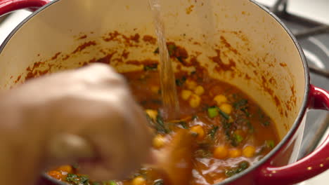 Geben-Sie-Brühe-Oder-Brühe-In-Den-Topf,-Während-Sie-Kichererbsen-Grünkohl-Suppe-Zubereiten