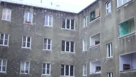 Cámara-Lenta-De-Copos-De-Nieve-Cayendo-Frente-Al-Antiguo-Edificio-Gris